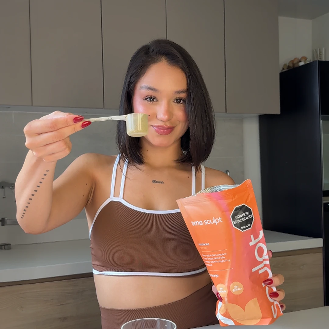 A customer holding a measuring scoop of SOMA Sculpt powder next to the product package.